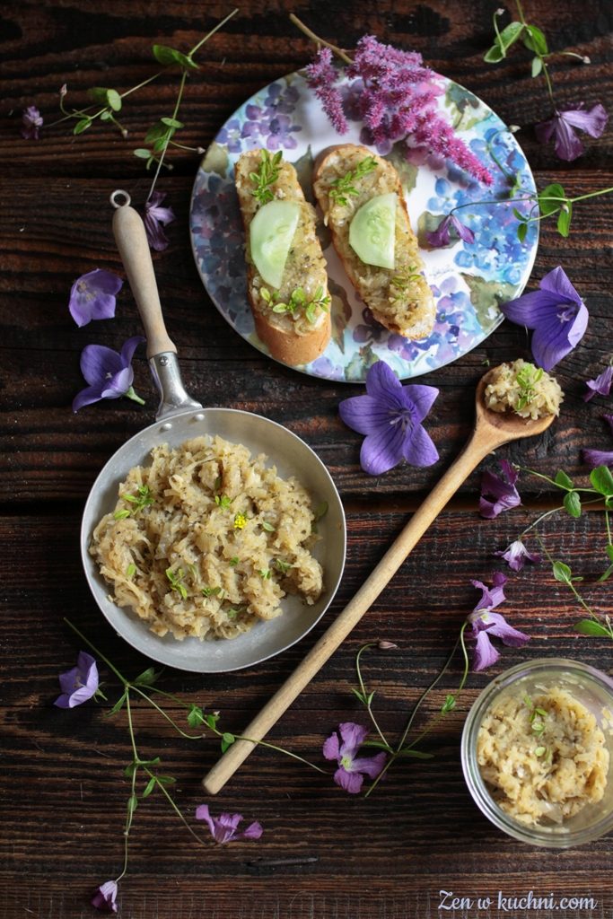 Smalec wegetariański z cebuli i jabłek podany na patelni, obok kromka chleba z ogórkiem