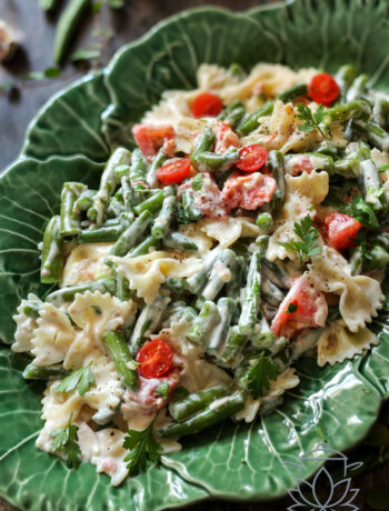 Makaron z fasolką szparagową w sosie mascarpone podany na zielonym talerzu